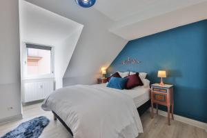 蒙斯特Le Moderne Vintage Hyper Centre, vue cigognes, montagne, neuf au calme, 3 étoiles的一间卧室设有一张大床和蓝色的墙壁