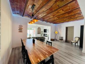 埃斯普卢加·德·隆布雷格Villa Paradise, urban oasis by -Toprentalsbarcelona-的一间带木桌和椅子的用餐室