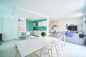 韦内雷港LA POMELLA的厨房以及带白色桌椅的起居室。