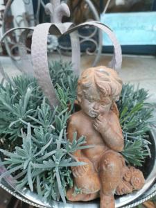 德兰斯克cafesahne u Pension的坐在植物里的一个小女孩的雕像