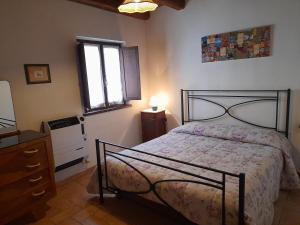 卡夏Agriturismo Casale Sant'Antonio的一间卧室配有一张床、一个梳妆台和一扇窗户。