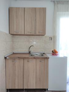 贝西奇Guest House Lotos的一个带木制橱柜和水槽的厨房