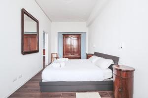 梅纳焦Casa Andrea的卧室配有白色的床和镜子