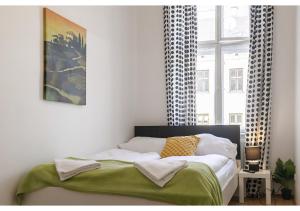 维也纳Viennese 3BR shared Apt. Near Wiener Stadthalle & Central的一间卧室配有一张带绿毯的床和窗户。
