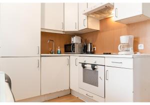 维也纳Viennese 3BR shared Apt. Near Wiener Stadthalle & Central的厨房配有白色橱柜和白色冰箱。