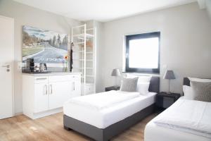 尼尔堡纽伦堡顶点酒店的一间白色卧室,配有两张床和窗户