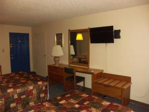 麦迪逊Deerwood Inn & Madison Campground的酒店客房配有书桌、床和镜子