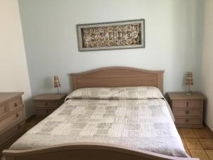 卡拉古诺内Appartamenti Manuela的一间卧室配有一张带2个床头柜和2盏灯的床。