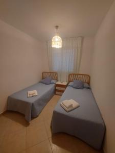 拉安蒂拉Aguamarina, cerca de todo的一间卧室配有两张床和吊灯。
