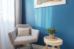 埃森Yggotel Solsort的蓝色墙壁的房间里一张椅子和一张桌子