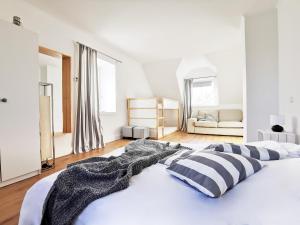 汉堡Haus am Deich 47 stilvolles Landhaus an der Elbe in Stadtnähe的白色卧室配有带条纹枕头的大床