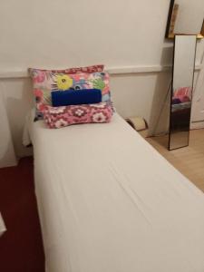 黎牙实比Maraño's Home的一张白色的床,上面有两个枕头