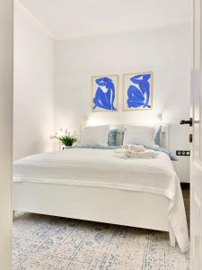 索非亚Vintage Top Centre Apartment的白色卧室配有一张白色大床和蓝色绘画