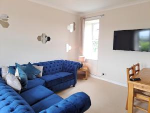 CanonbieBogrie Cottage的客厅配有蓝色的沙发和电视