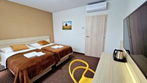 瓦赫河畔杜布尼察Hotel Kristína的酒店客房配有一张床铺和一张桌子。