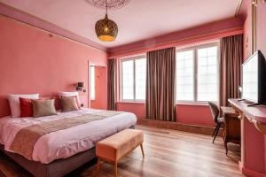 WatervlietBoutique hotel Sies的卧室设有粉红色的墙壁、一张床和一张书桌