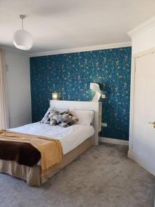 都柏林The Milltown Apartment的一间卧室配有一张蓝色墙壁的床
