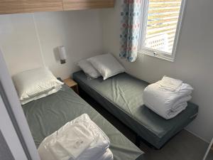 圣乔治-德迪多讷mobil home 6 places tout confort的小房间设有两张床和窗户
