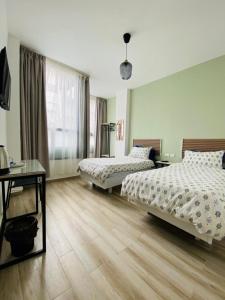 安曼Arabesque Hotel的一间卧室设有两张床、一张桌子和一个窗口