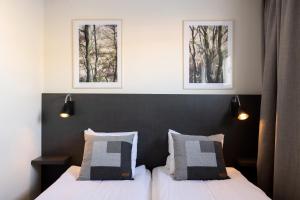 莫拉Hotel Bishops Arms Mora的卧室配有两张床,墙上挂有两张照片