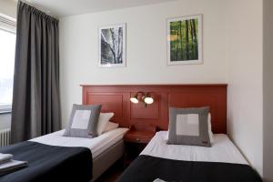莫拉Hotel Bishops Arms Mora的酒店客房设有两张床和窗户。