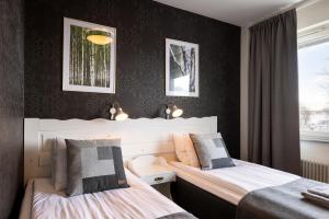 莫拉Hotel Bishops Arms Mora的配有黑色墙壁的客房内的两张床