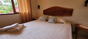 San José de ChiquitosRústico & Hotel Boutique Las Churapas的卧室配有一张白色大床和木制床头板