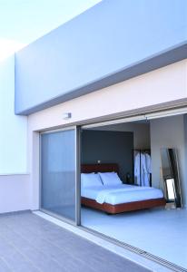 PaianíaSpacious & Minimal Apartment Near Airport Peania Coniann Filoxenia的一间卧室设有一张床和一个滑动玻璃门