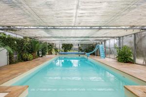 La GaudaineLarge contemporary house with indoor swimming pool的大楼内一个带滑梯的游泳池