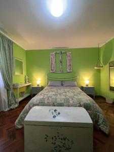 法布里亚诺B&B Casa Caporali的一间卧室设有一张带绿色墙壁的大床
