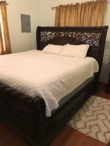 圣费尔南多Comfortable home in San Fernando的卧室内的一张带白色床单和枕头的床
