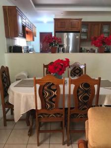 圣费尔南多Comfortable home in San Fernando的厨房配有桌椅和鲜花