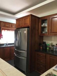圣费尔南多Comfortable home in San Fernando的厨房配有不锈钢冰箱和木制橱柜