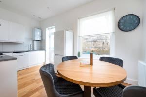 伦敦Trendy East London Flat BRO1的厨房配有木桌、椅子和时钟