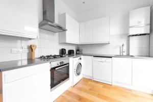 伦敦Trendy East London Flat BRO1的白色的厨房配有炉灶和洗碗机。