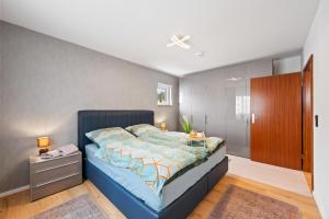 莱茵河畔路德维希港Minty Lounge的一间卧室配有蓝色的床和木制橱柜