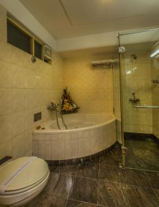班加罗尔排总督酒店的带浴缸、卫生间和淋浴的浴室。