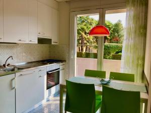 洛索内西厄斯塔公园加尼别墅酒店的厨房配有带绿色椅子的桌子和窗户。