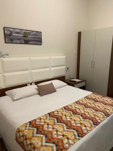 佩尼多POUSADA ESTÂNCIA的一间卧室配有一张带彩色毯子的床