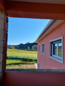 SapatariaCasa Susana的享有田野景致的粉红色房屋窗户