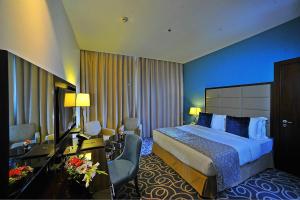 阿布扎比阿布扎比滨海路华美达酒店的配有一张床和一张书桌的酒店客房