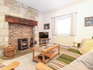 莫珀斯Canny Cottage的客厅设有石制壁炉和沙发。