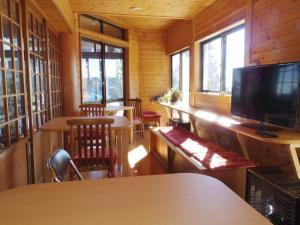 青梅市歌鸲桑索宿坊酒店的客房设有桌椅和平面电视。