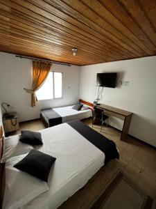 亚美尼亚Hotel Alpino的一间卧室配有一张大床和一张书桌