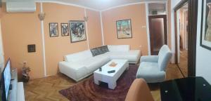 尼什Shangri La Residence的客厅配有白色的沙发和桌子