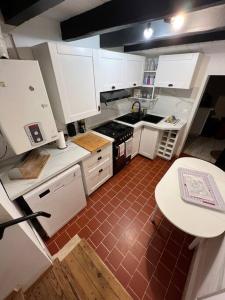 Gargilesse-DampierreCharmante maison berrichonne的厨房配有白色橱柜和红色瓷砖地板。