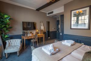 赫特福德索尔兹伯里纹章酒店的一间卧室配有两张床、一张桌子和一台电视。