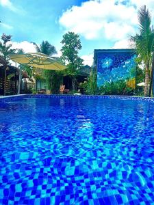 Cái RăngBến Đò Xưa Homestay & Coffee的大楼前方的蓝色瓷砖大型游泳池