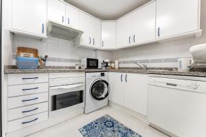 福恩吉罗拉Doña Sofía的厨房配有白色橱柜、洗衣机和烘干机