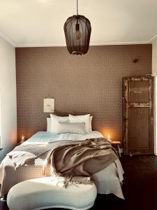 卡斯特里科姆Boutique Hotel het Oude Raadhuis的一间卧室配有一张大床和一个吊灯。